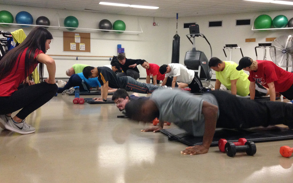 A group of athletes does push-ups in a fitness center.