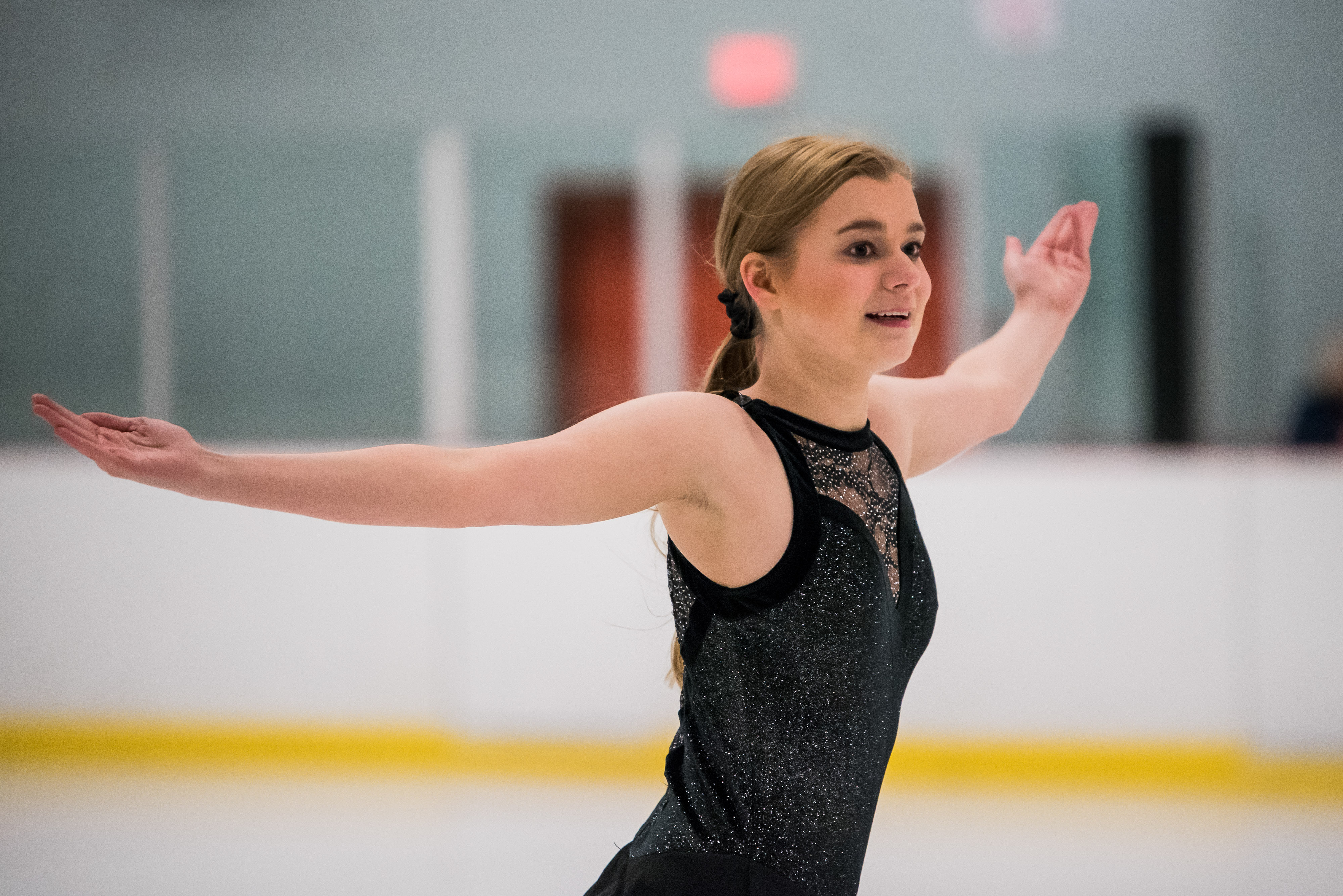Special Oylmpics BC figure skating athlete finishes her performance with her arms outstretched and a satisfied smile on her face. Special Oylmpics BC figure skating athlete finishes her performance with her arms outstretched and a satisfied smile on her face.